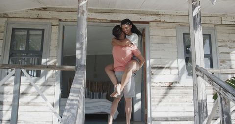 Joyful Couple Embracing on Sunny Beach House Steps - Download Free Stock Images Pikwizard.com