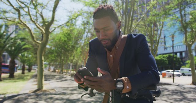 Professional businessman on break using smartphone while riding bicycle in urban park - Download Free Stock Images Pikwizard.com