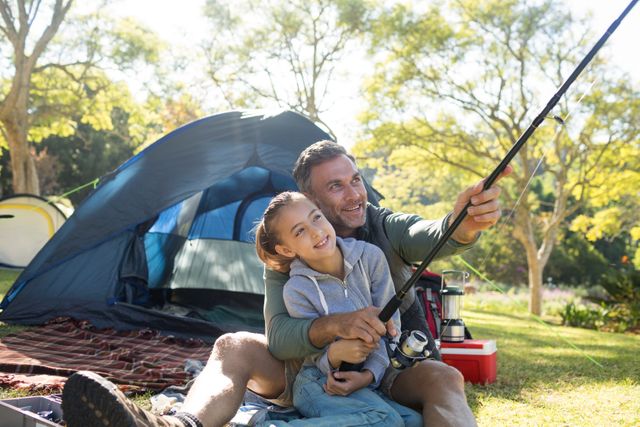Father and daughter holding a fishing rod outside the tent while fly fishing