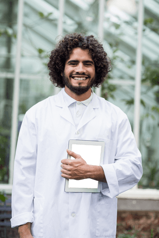 transparent smiling male researcher in white lab coat holding tablet - Download Free Stock Videos Pikwizard.com