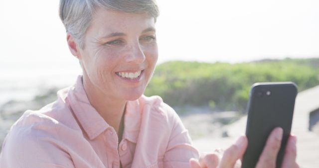 Smiling Mature Woman Using Smartphone Outdoors, Enjoying Sunny Day - Download Free Stock Images Pikwizard.com