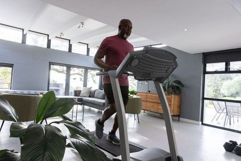 Senior Man Exercising on Treadmill in Modern Home Gym