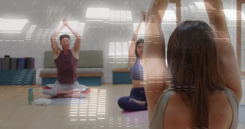 Adults Practicing Yoga in Bright Studio Raising Arms During Group Wellness Class With Mats