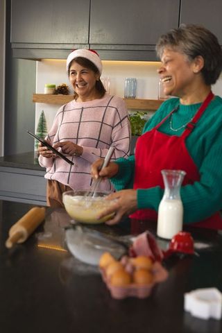 Friends joyfully preparing holiday cookies in modern kitchen