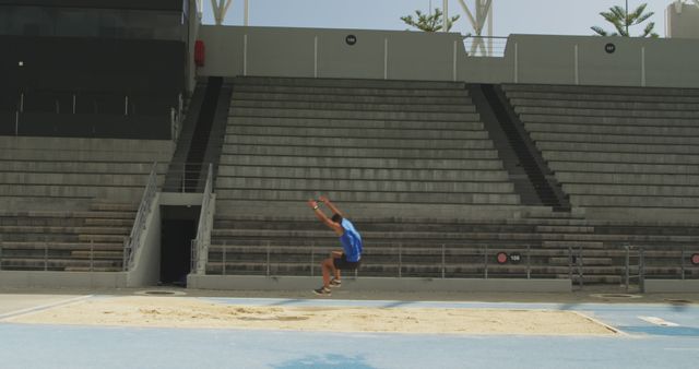 Male Athlete in Mid-air Long Jump at Empty Stadium - Download Free Stock Images Pikwizard.com