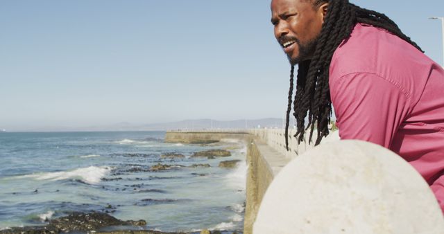 Man with Black Braids Relaxing by Oceanfront Seawall - Download Free Stock Images Pikwizard.com