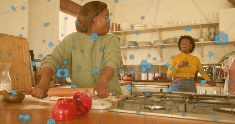 Friends baking together in cozy home kitchen rolling dough laughing and sharing moments