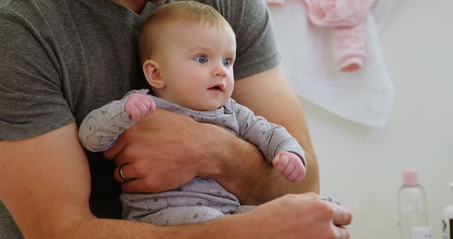 Father Cradling Infant in Gray Onesie - Download Free Stock Images Pikwizard.com