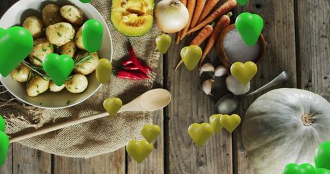 Rustic flatlay of baby potatoes and seasonal vegetables with floating green heart icons