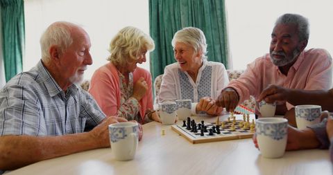 Senior Friends Engaged in Fun Chess Game Socializing