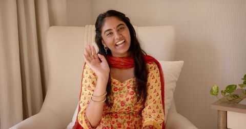 Woman in traditional indian sari sitting and smiling at home