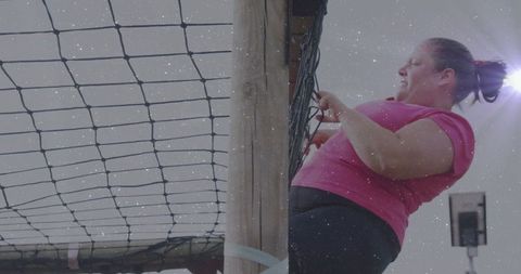 Woman Climbing Cargo Net in Outdoor Gym Workout