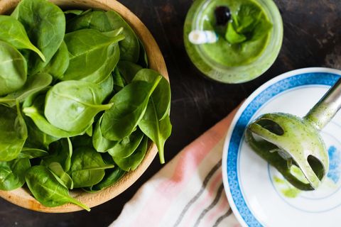 Blending Fresh Spinach into Green Smoothie with Wooden Bowl and Immersion Blender