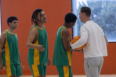 Inclusive Male Basketball Team with Coach on Indoor Court