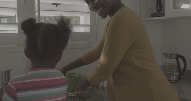 Smiling Mother Washing Dishes with Her Young Daughter in Kitchen - Download Free Stock Images Pikwizard.com