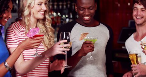 Diverse Group of Friends Enjoying Drinks at Nightlife Bar