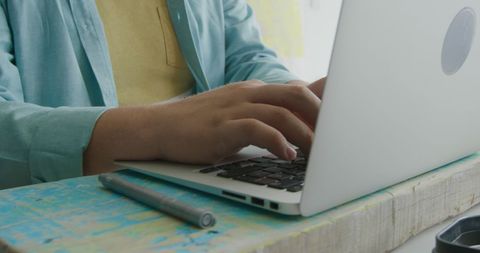 Man Typing on Laptop in Surfboard Stall