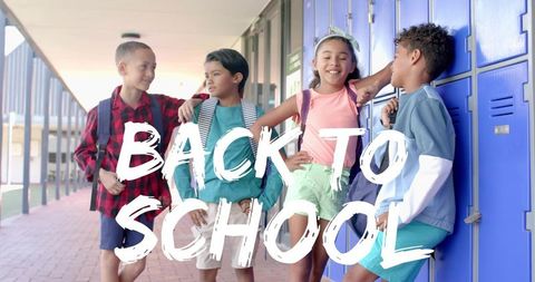 Elementary students chatting by blue lockers on back to school day, smiling and laughing