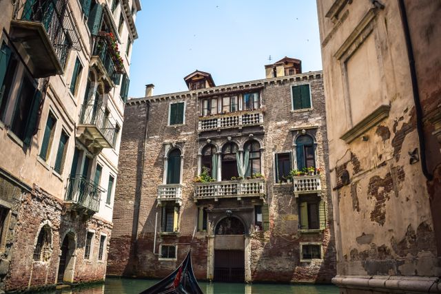 Image captures picturesque Venetian canal scene with historic buildings in Italy. Useful for travel blogs, tourism websites, or promoting European destinations. Ideal for illustrating historic architecture and romantic ambiance.