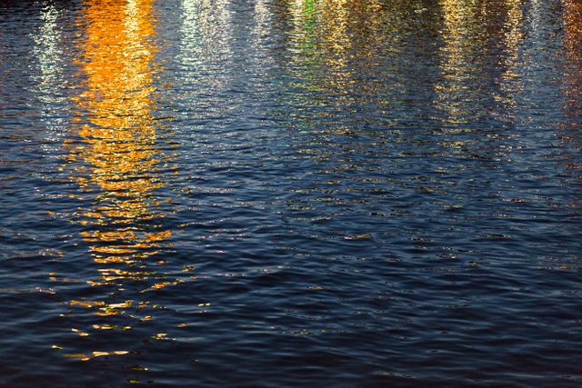 Colorful reflections in dark rippling water - Download Free Stock Photos Pikwizard.com