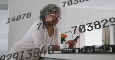 Senior Woman Engaged with Smartphone Technology in Kitchen