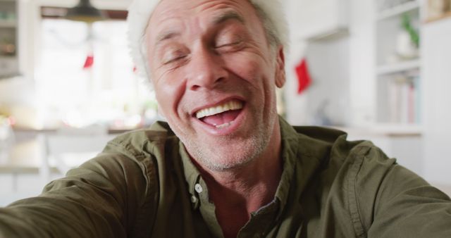 Older man wearing Santa hat laughing in festive kitchen - Download Free Stock Images Pikwizard.com