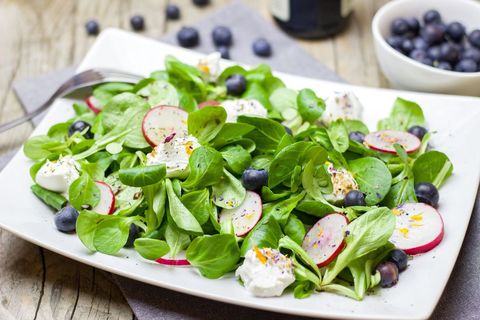Serving fresh mache salad with blueberries, radish and whipped goat cheese