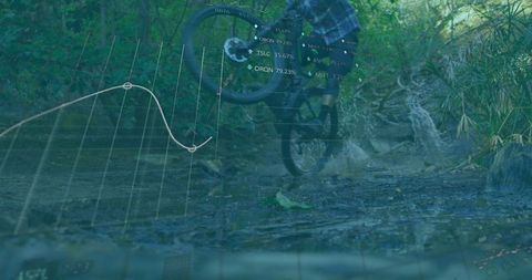 Mountain biker performing wheelie on muddy trail with data overlay