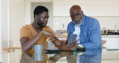 Father and Son Bonding Over Technology in Modern Kitchen