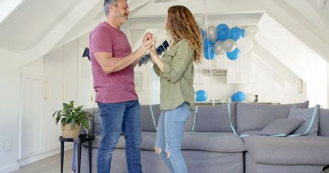 Couple Dancing Joyfully in Festive Living Room
