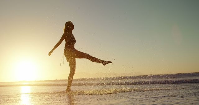 Woman Kicking Water at Sunset on Beach - Download Free Stock Images Pikwizard.com