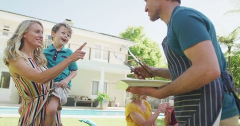 Joyful Family Enjoying Backyard Barbecue on Sunny Day