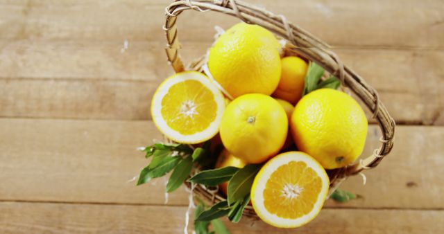 A basket filled with fresh, ripe oranges sits on a wooden surface, with one orange cut in half to reveal the juicy interior. Vibrant and refreshing, the image captures the essence of healthy eating and the natural simplicity of fruit.