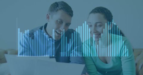Couple Analyzing Finances with Digital Graphs Overlay