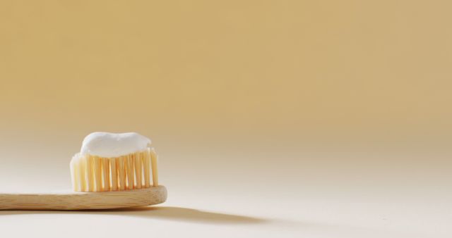 Close up of toothbrush with paste on beige background with copy space. Beauty products, cosmetics and skincare concept.