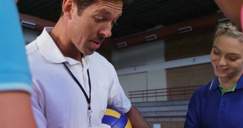 Coach Demonstrating Volleyball Techniques to Teen Players