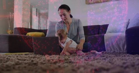 Caregiver holding baby using laptop on plush high-pile carpet in bright living room