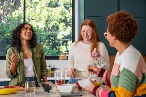 Diverse Women Preparing Fruit in Bright Kitchen