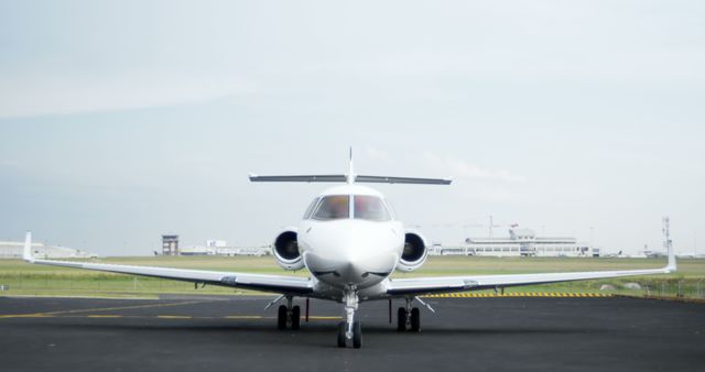 A private jet is parked on the tarmac, with copy space. Luxury air travel is depicted by the sleek design of the aircraft against an expansive sky.