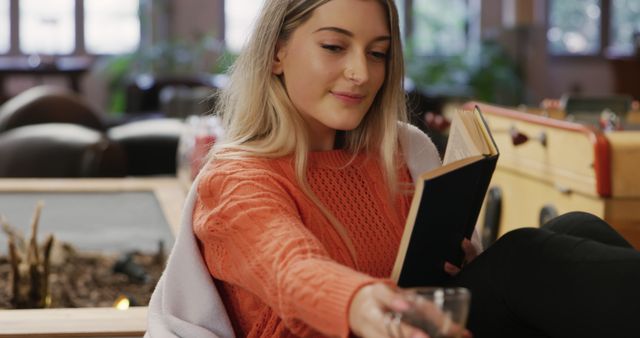 Young Woman Relaxing with Book and Drink in Cozy Cafe - Download Free Stock Images Pikwizard.com