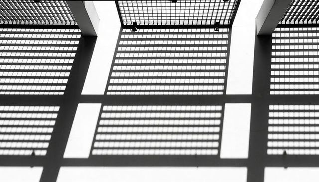 Monochrome Skylight Grid Casting Bold Geometric Shadows Across Minimalist Ceiling Abstract