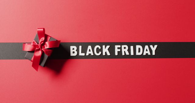 Black Friday sale banner with black gift box tied with red ribbon on minimalistic red background. Perfect for advertising Black Friday sales, promotional events, and retail bargains. Eye-catching visual ideal for posters, social media posts, and marketing materials to attract shoppers.