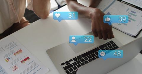 Women collaborating on social media analytics dashboard on laptop with reports and charts