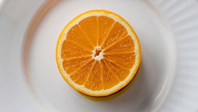 Halved Orange on White Plate Showcasing Freshness and Vibrancy