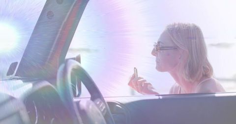 Woman Applying Lip Balm in Car Just Near Waterfront