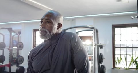 Senior man resting between workouts in modern gym