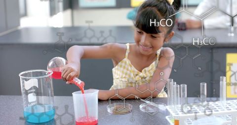 Young girl exploring chemistry with colorful liquids in laboratory study
