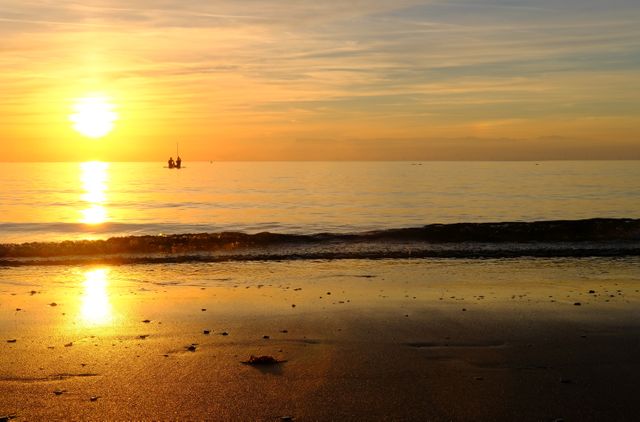 Tranquil Seaside Sunset with Silhouetted Boat - Download Free Stock Photos Pikwizard.com