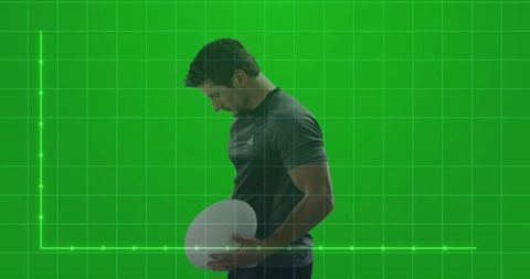 Athletic male holding oval ball on futuristic green screen