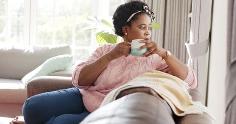 African American Woman Relaxing with Hot Drink at Home
